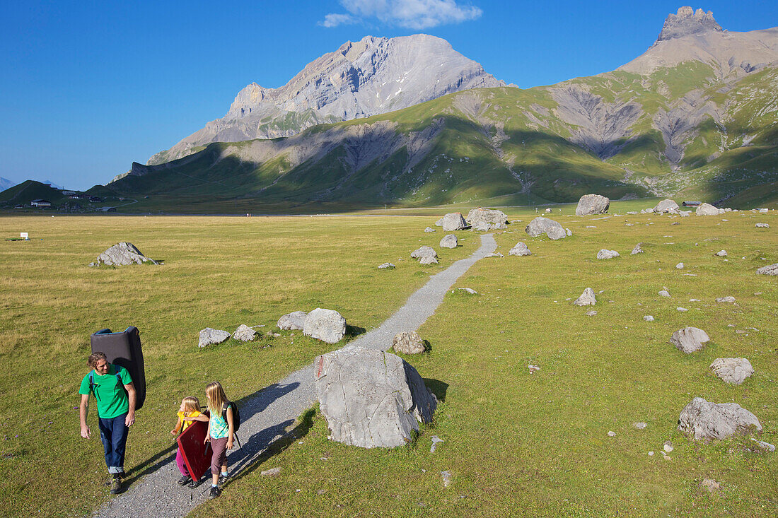 Two girls and a man bouldering, climbing, Engstligenalp, Bernese Oberland, Switzerland