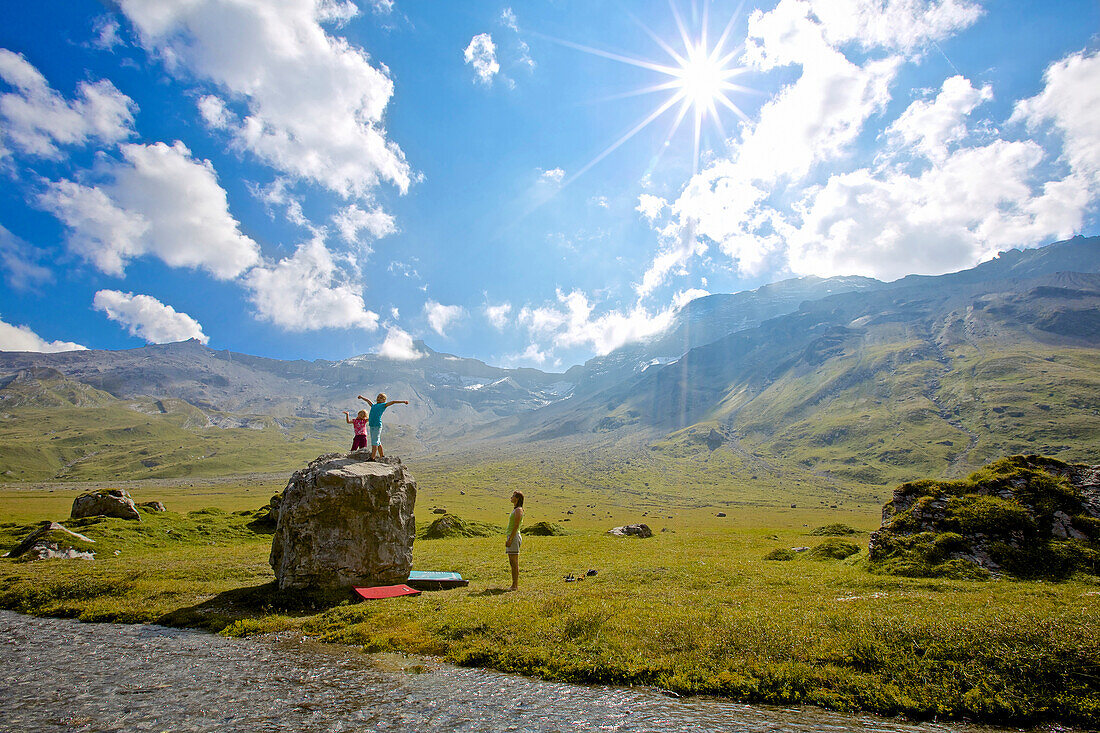 Two girls and a woman, a mother bouldering, climbing, Engstligenalp, Bernese Oberland, Switzerland