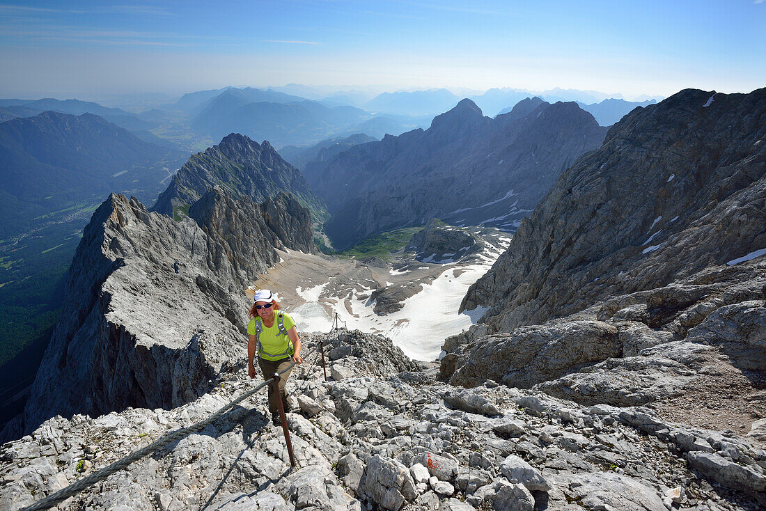 Woman ascending on fixed rope route to Zugspitze, glacier Hoellentalferner in background, Wetterstein mountain range, Upper Bavaria, Bavaria, Germany