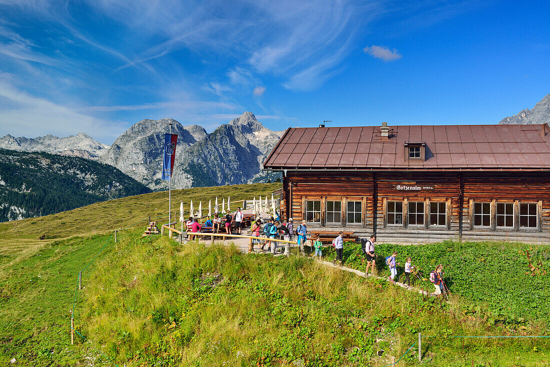 Hikers leaving alpine hut in front of Hundstod, Gotzenalm, Berchtesgaden National Park, Berchtesgaden Alps, Upper Bavaria, Bavaria, Germany