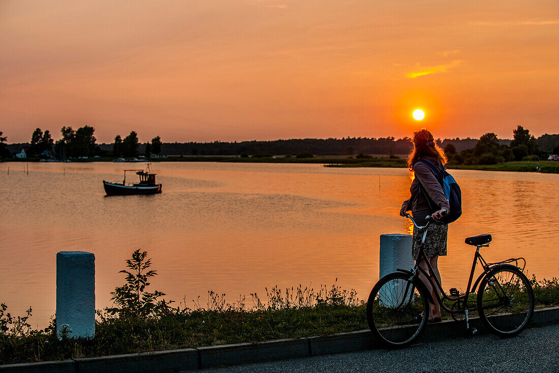 Frau schaut in den Sonnenuntergang auf der Insel Ummanz, Insel Rügen, Mecklenburg-Vorpommern, Norddeutschland, Deutschland