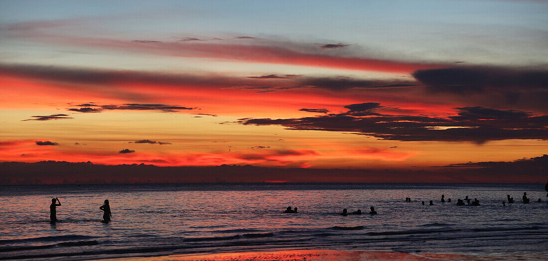 Menschen baden bei Sonnenuntergang, Boracay, Aklan, Philippinen