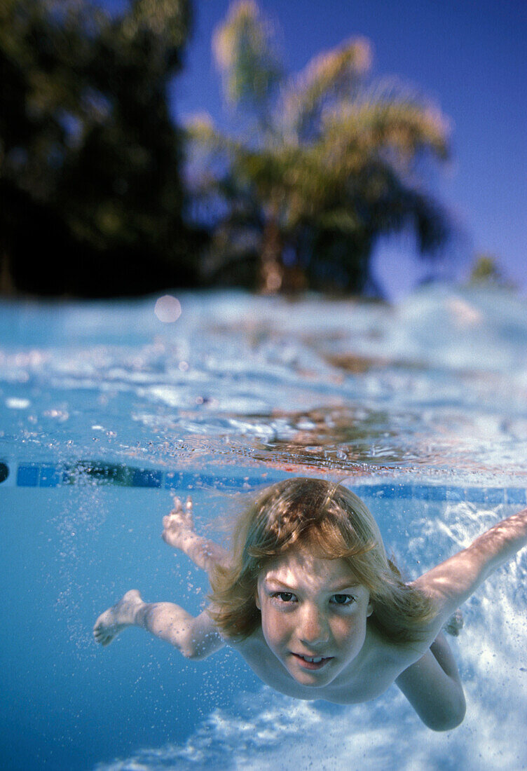 Blond boy Swimming in Pool Underwater