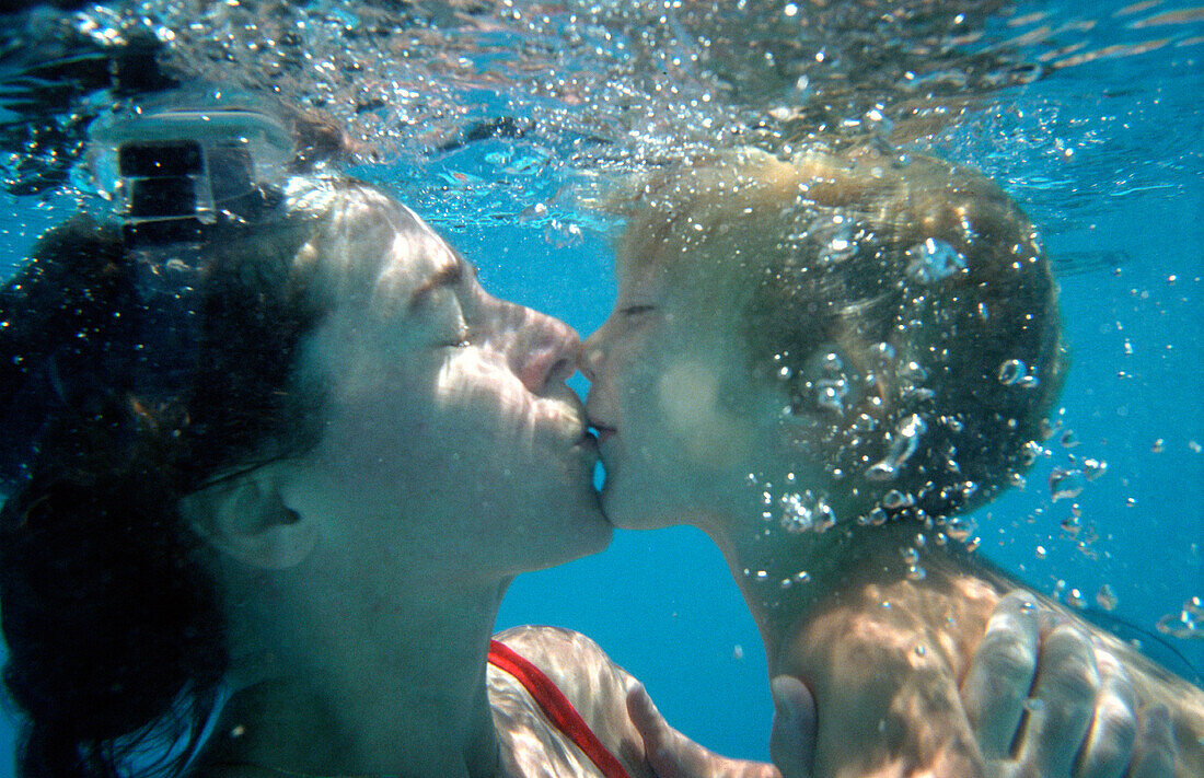 Mutter und Sohn küssen sich unter Wasser