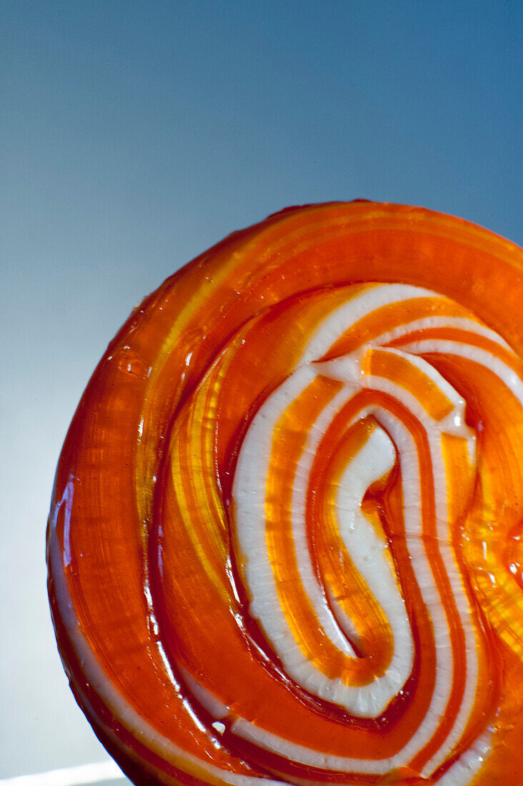 Orange Swirl Lollipop on Blue Background