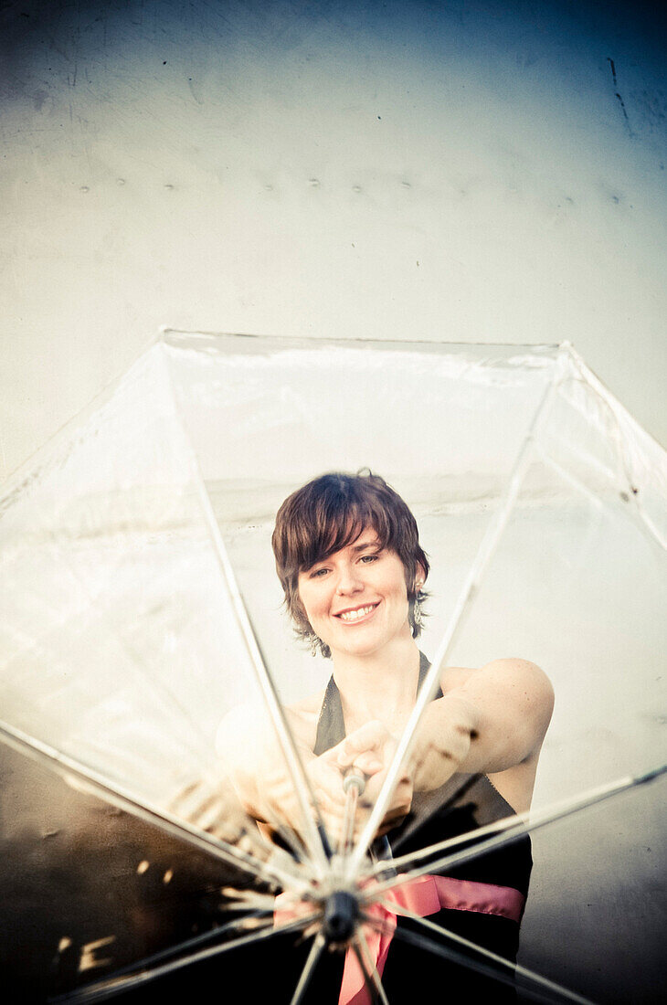 Young Woman Smiling Through Clear Umbrella