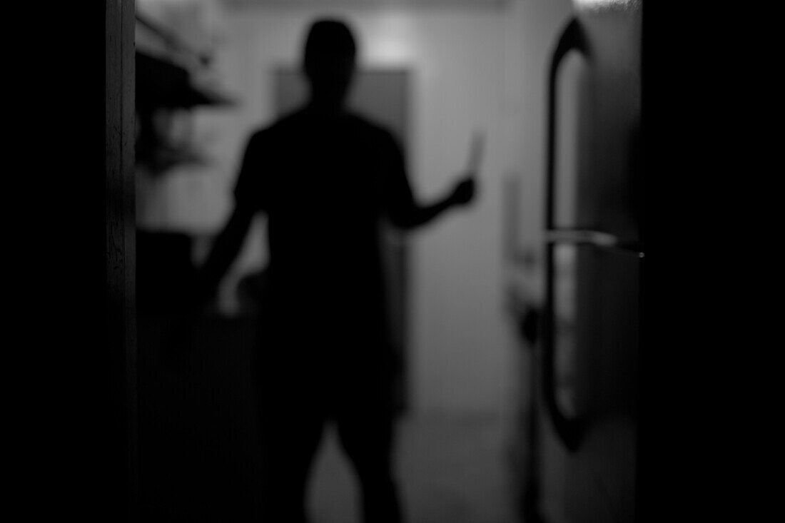 Man Holding Knife in Kitchen, Rear View, Silhouette