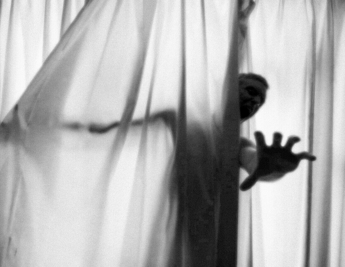 Screaming Man's Hand Reaching  out from Curtains