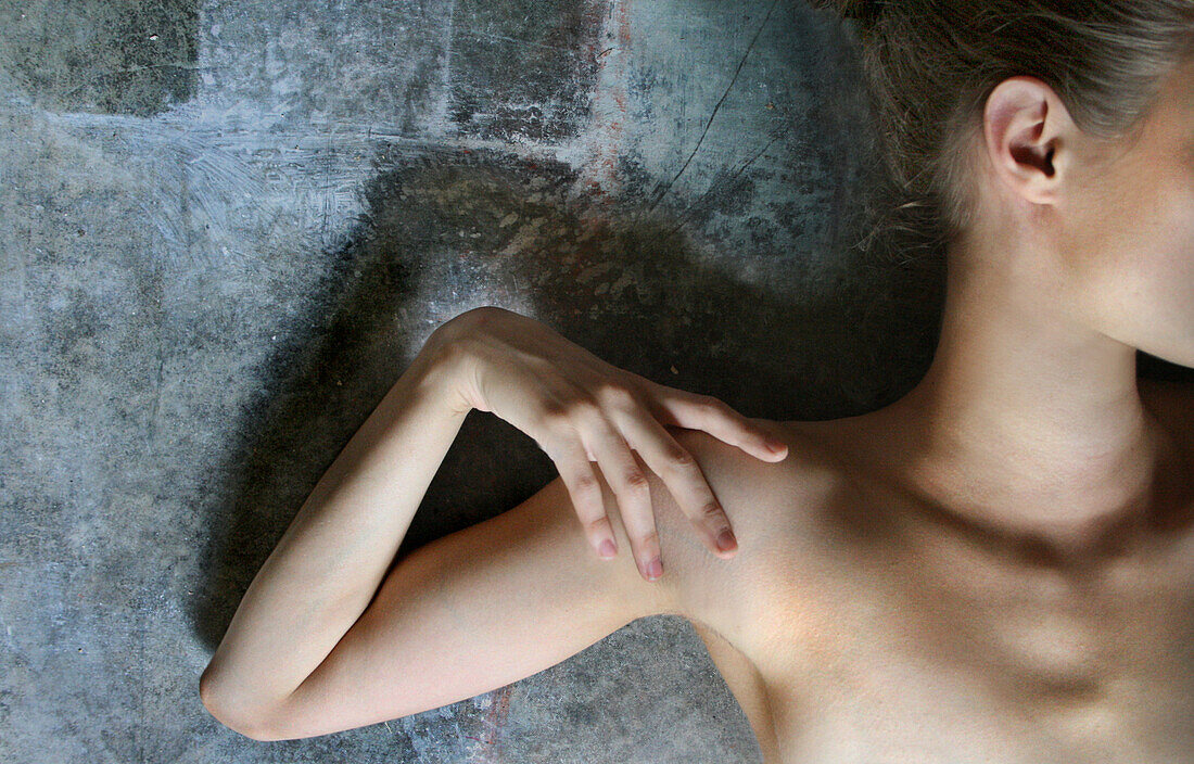 Nackte Frau in künstlerischer Pose, Hand berührt Schulter