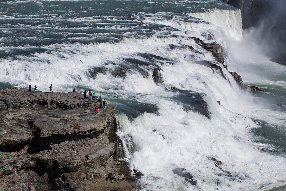 Tourists In Front Of The Gullfoss Falls, A 32-Meter High Waterfall, Region Of The Golden Circle, Iceland