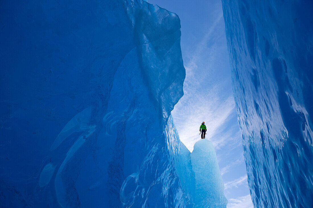 An Ice Climber Surveys A Wide Crevasse From Within Mendenhall Glacier, Juneau, Southeast Alaska, Winter
