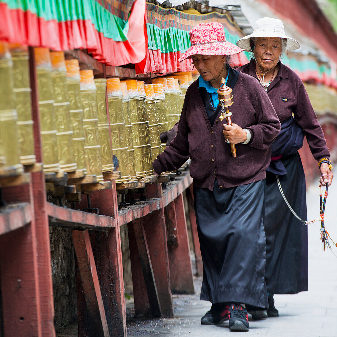 'China, Xizang, Women Walking Together along Prayer Wheels at Potala Palace; Tibet'