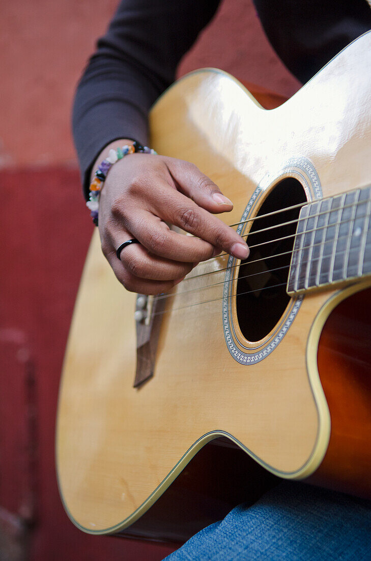 'Mexico, Guanajuato, Female Musician Strumming Acoustic Guitar; Guanajuato'