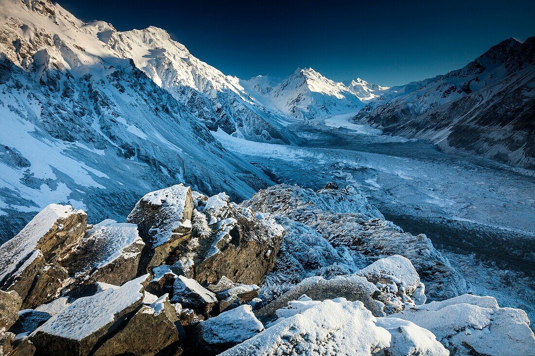 Snow covered boulders on Ball hut ridge, pre-dawn light, Tasman glacier below, Aoraki Mount Cook National Park, Canterbury