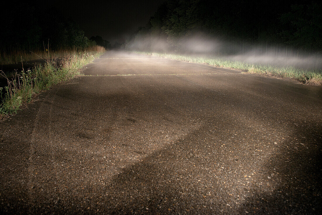 Fog at night over a road at Fliegerhorst - former military airbase, Leipheim near Guenzburg, Swabia, Bavaria, Germany