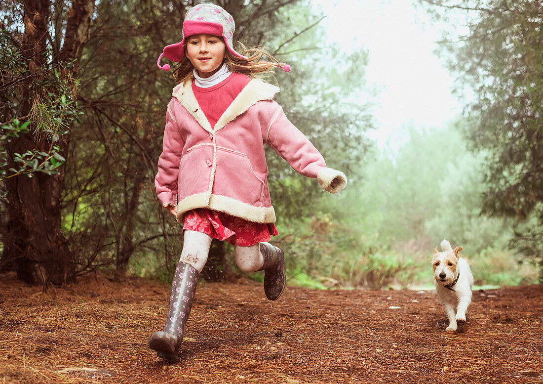 A girl and her dog running down a path, Malaga andalusia spain