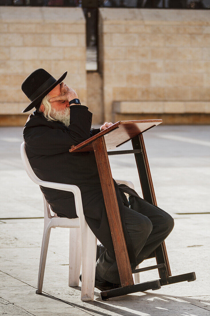 Side view of man with Wailing Wall in background, Jerusalem, Israel