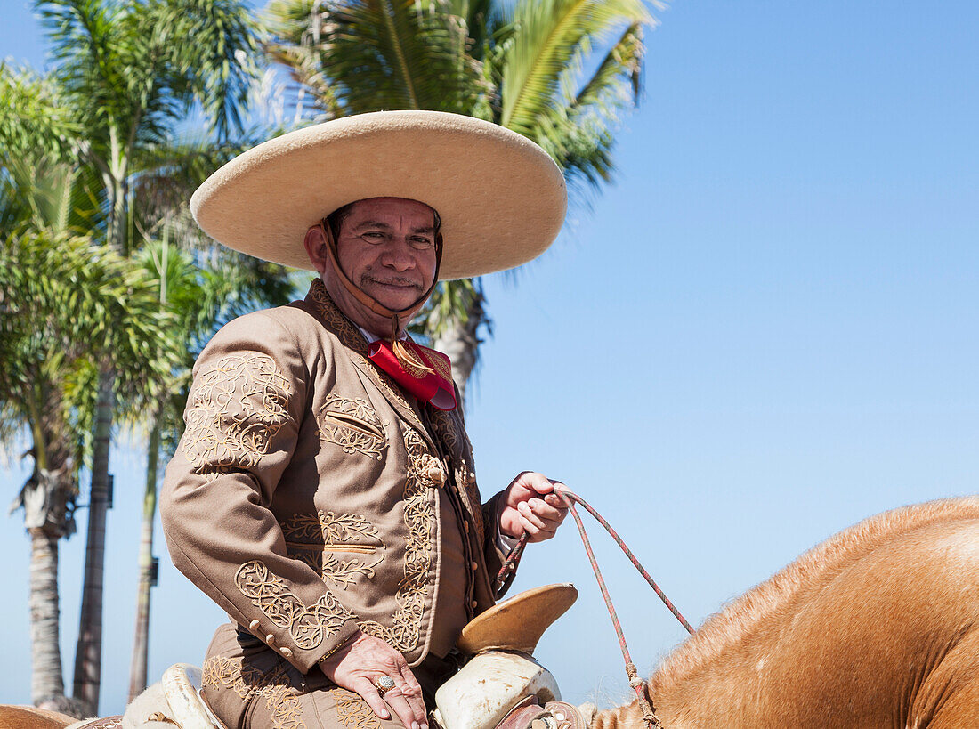 Man riding horse and dressed for Mexican rodeo and parade, Puerto Vallarta, Mexico