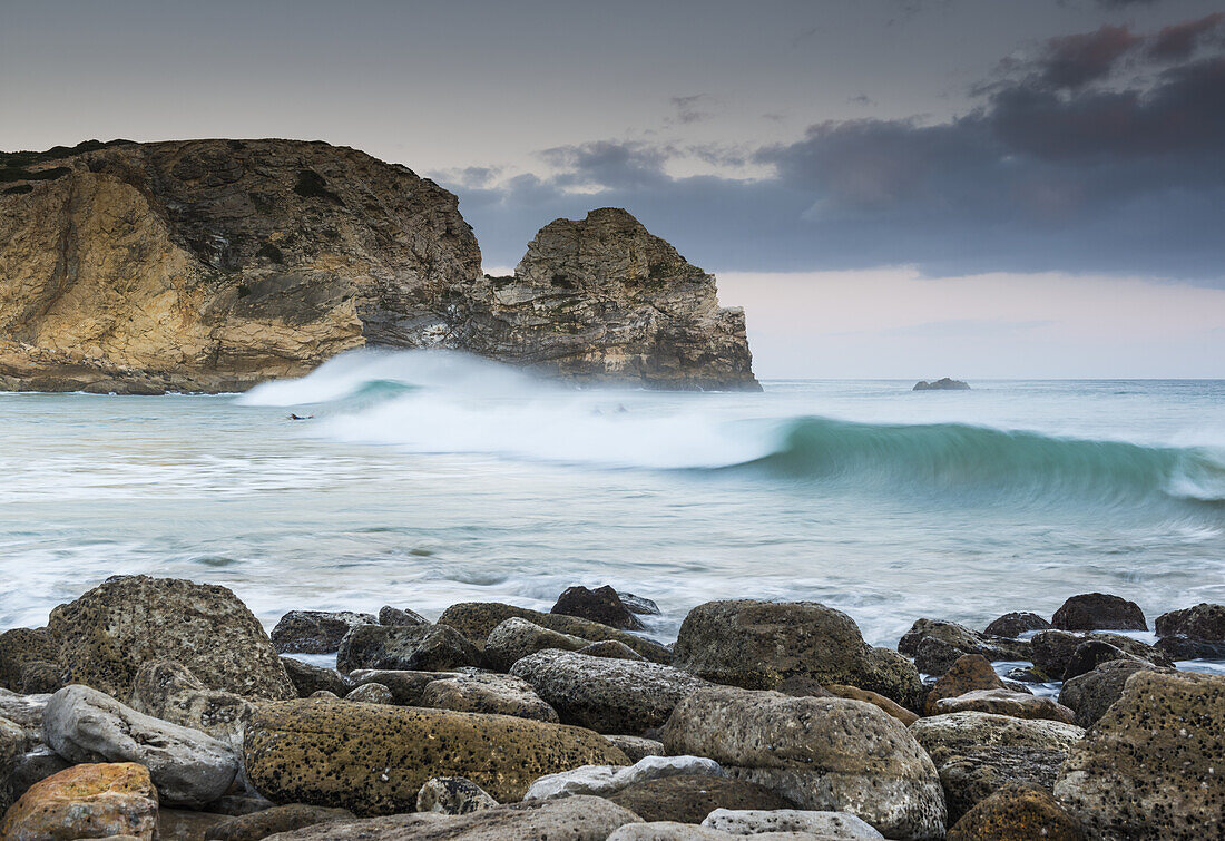Portugal, Algarve, Waves crashing into rocks and boulders on shore, Sagres