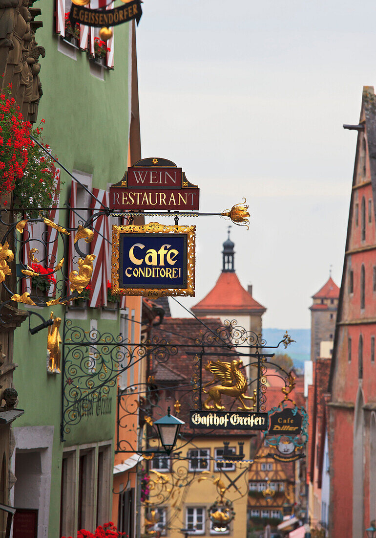 Colorful sign ornaments on top of each shop or restaurant, Rothenburg ob der Tauber, Bavaria, Germany