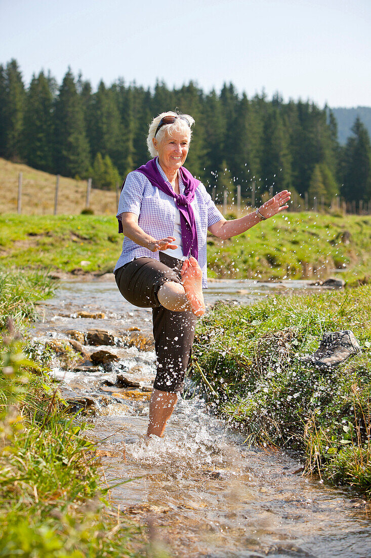 Female hiker refreshing in a stream, Styria, Austria