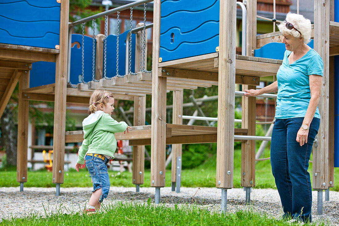 Grandmother and girl (3 years) on a playground, Styria, Austria