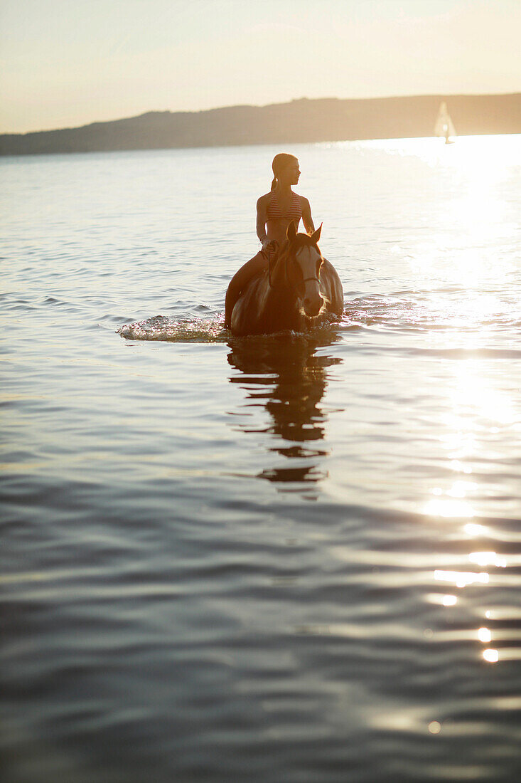Girl riding a horse in lake Starnberg, Ammerland, Munsing, Upper Bavaria, Germany