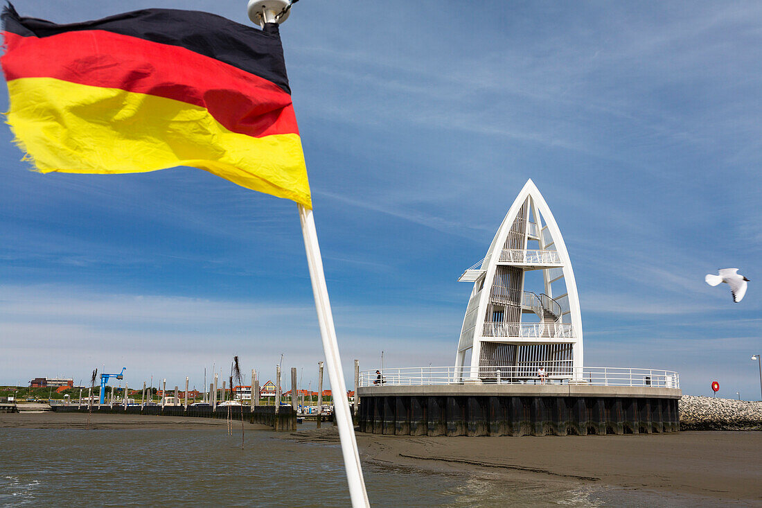 German flag at Juist harbour with observation tower in the background, landmark, Juist Island, Nationalpark, North Sea, East Frisian Islands, East Frisia, Lower Saxony, Germany, Europe