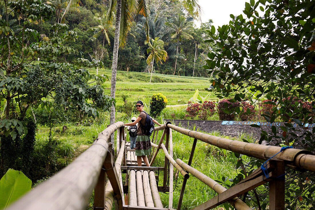 Woman passing a bamboo bridge, Karangasem, Bali, Indonesia