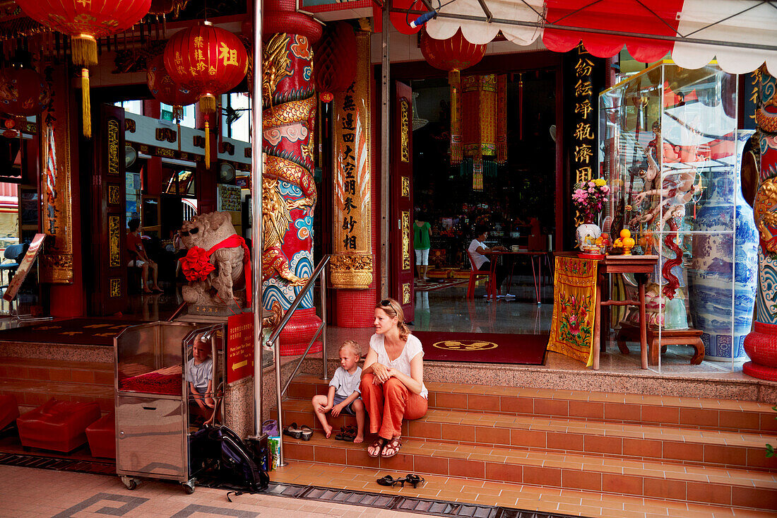 Mother and son sitting on steps of a temple, Chiantown, Singapore