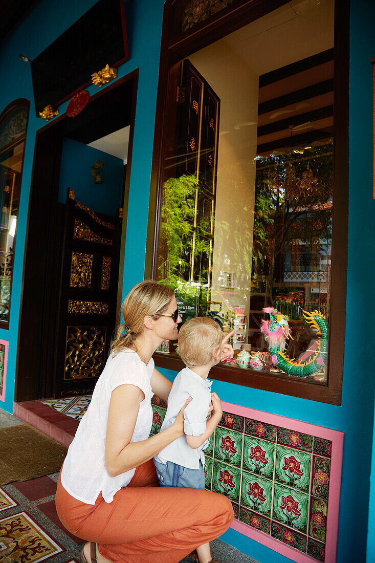 Mutter und Sohn schauen in einen asiatischen Antiquitätenladen, Chinatown, Singapur