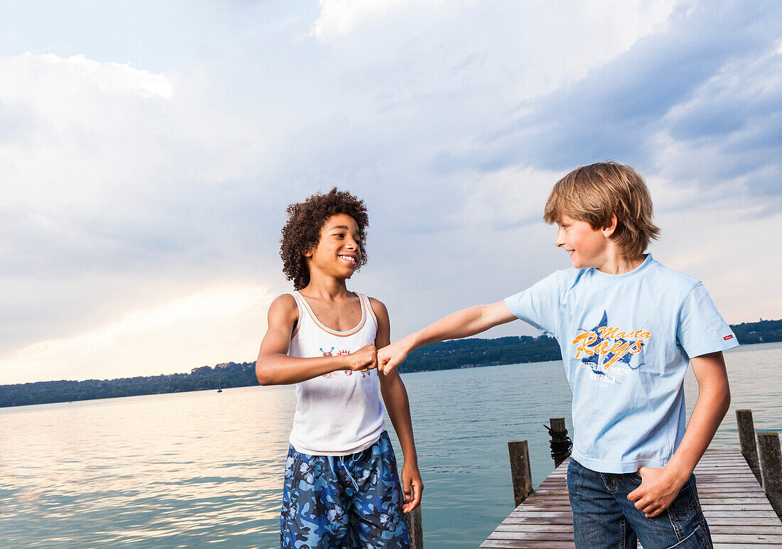 Two boys on a jetty at lake Starnberg, Upper Bavaria, Germany