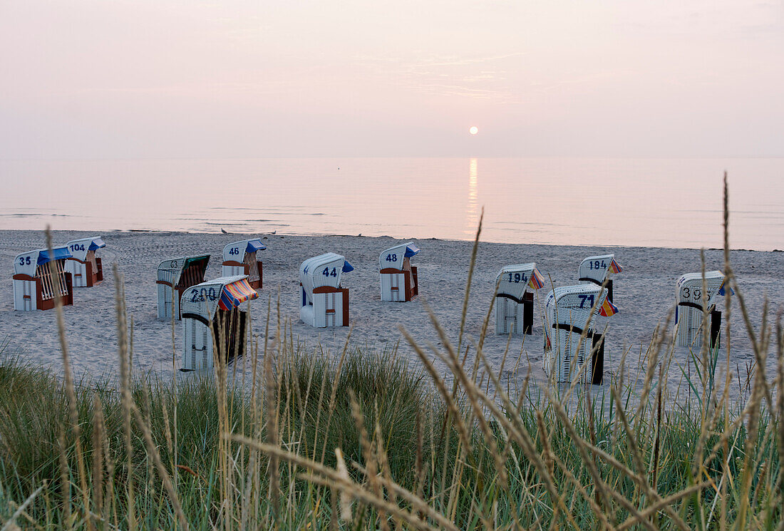 Hooded beach chairs on the beach at sunset, Baltic Sea, Groemitz, Schleswig-Holstein, Germany