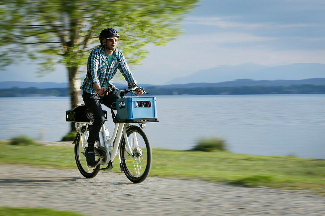 Man cycling with an E-bike along lake Starnberg, Upper Bavaria, Germany