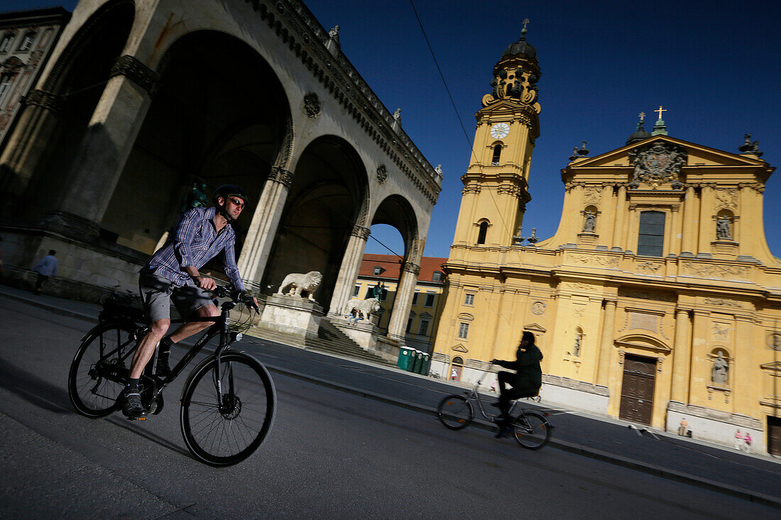 Man with an e-bike crossing Odeonsplatz, Munich, Upper Bavaria, Germany