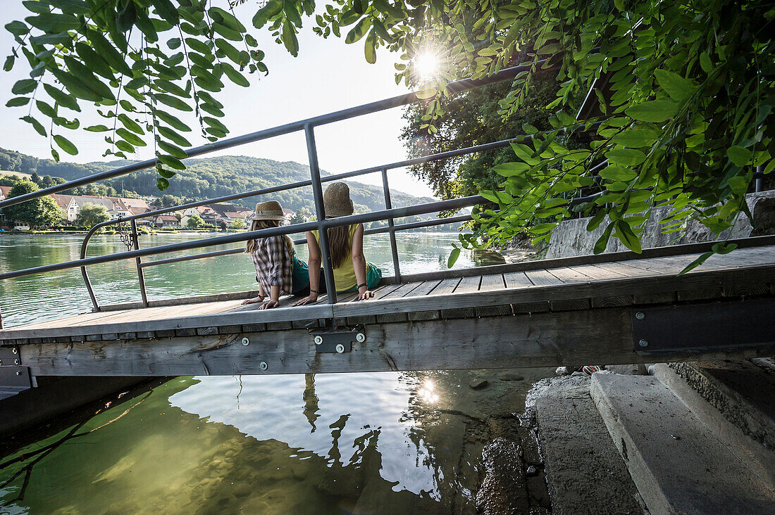 Two young women at river Rhine, Rheinfelden, Baden-Wuerttemberg, Germany