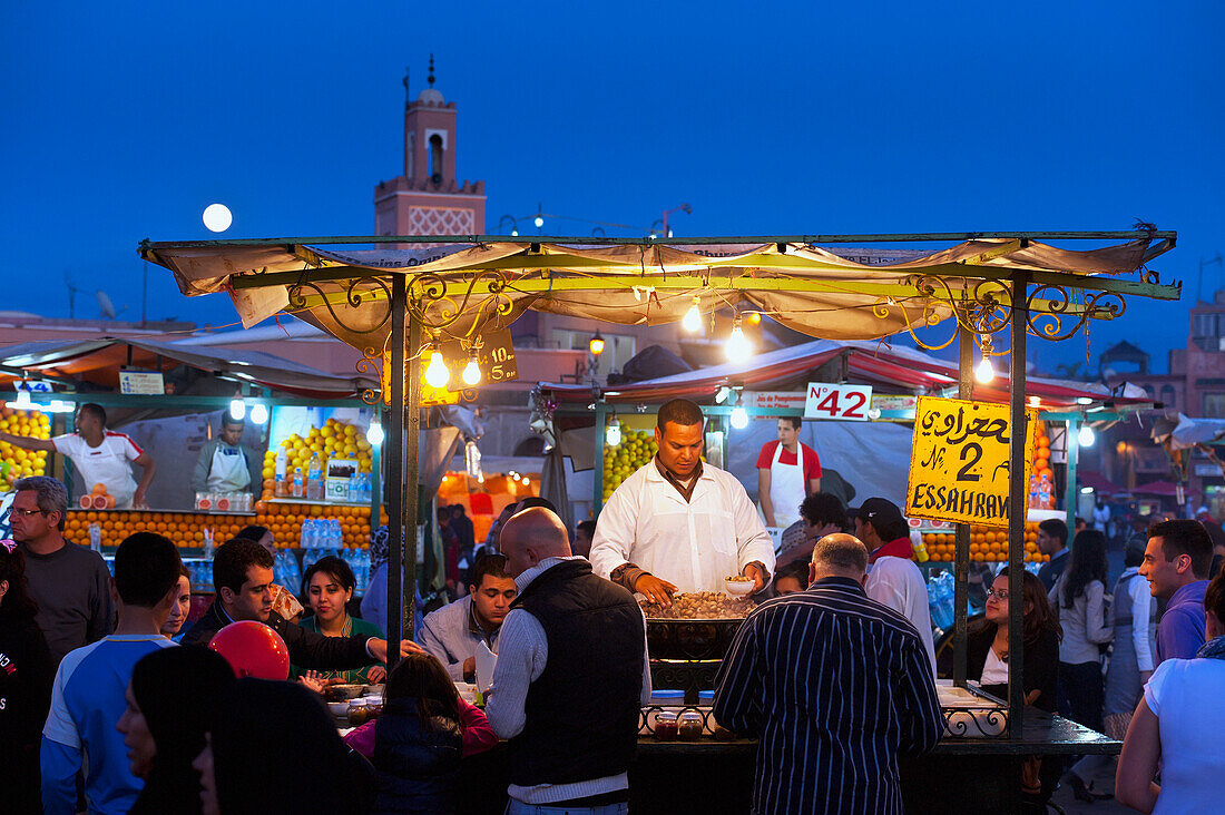 Cook serving food at stall in Djemaa el-Fna Square, Marrakech, Morocco