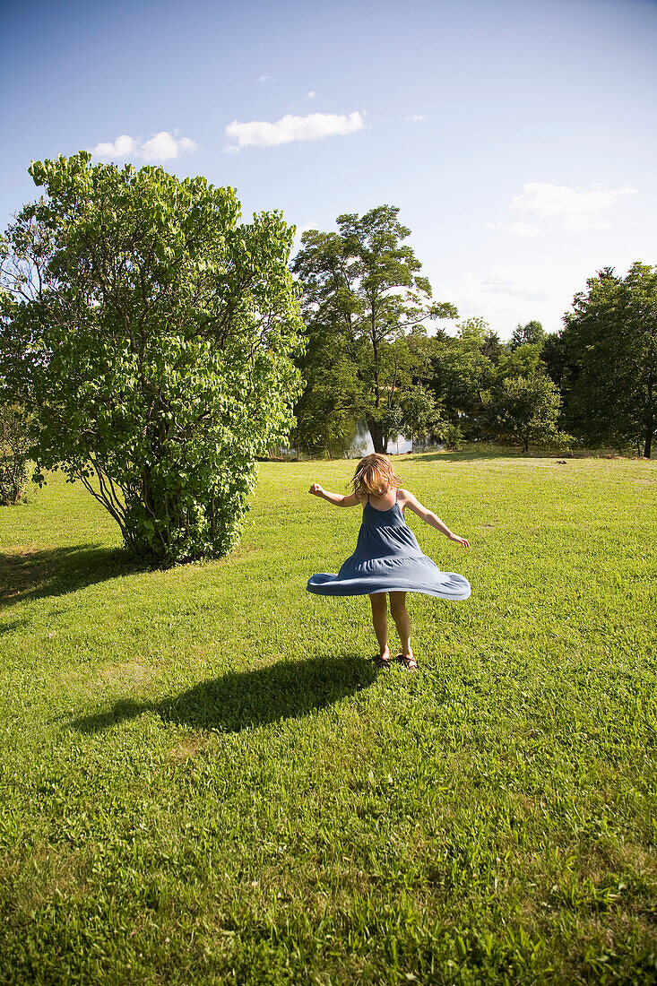 USA, New York State, Girl spinning on green grass, Hudson Valley