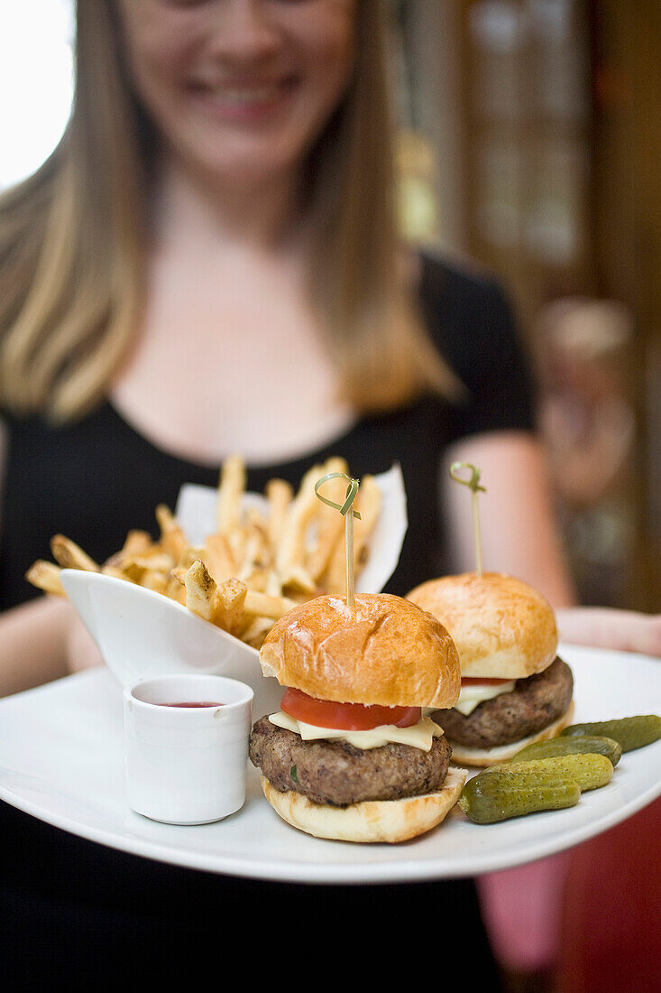 USA, New York State, Waitress with fries and hamburger in Cinema Restaurant, New York City