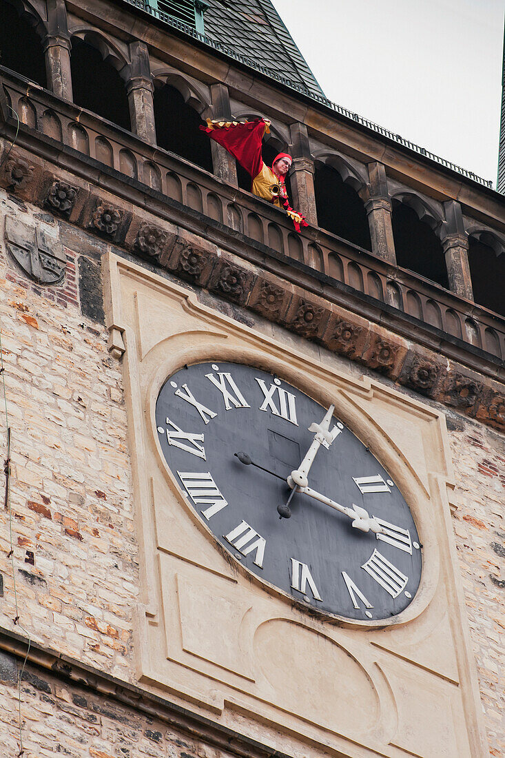 Trumpet player waving to people from Town Hall tower, Prague, Czech Republic