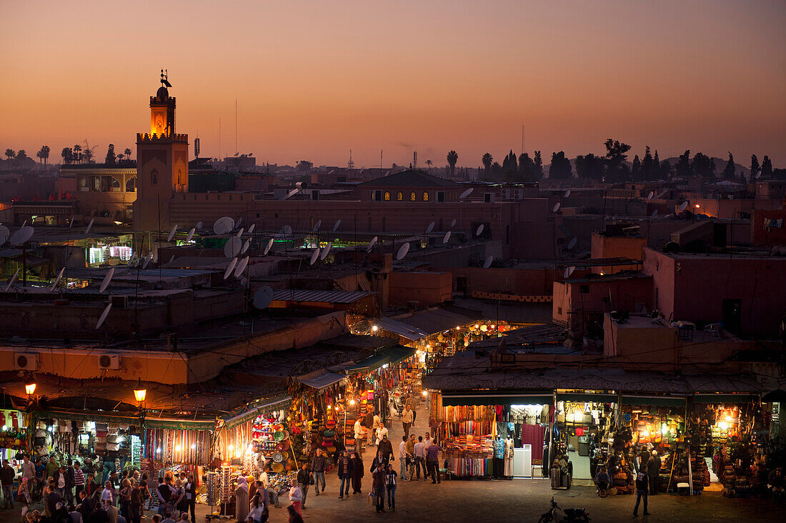 Looking over entrance to souks at dusk at edge of Djemaa El Fna, Marrakesh, Morocco