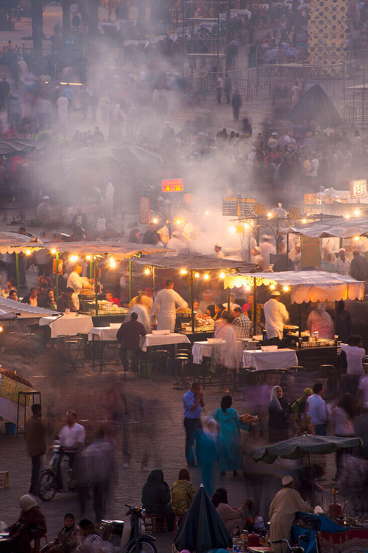 People and food stalls in Djemaa el Fna at dusk, Marrakesh, Morocco