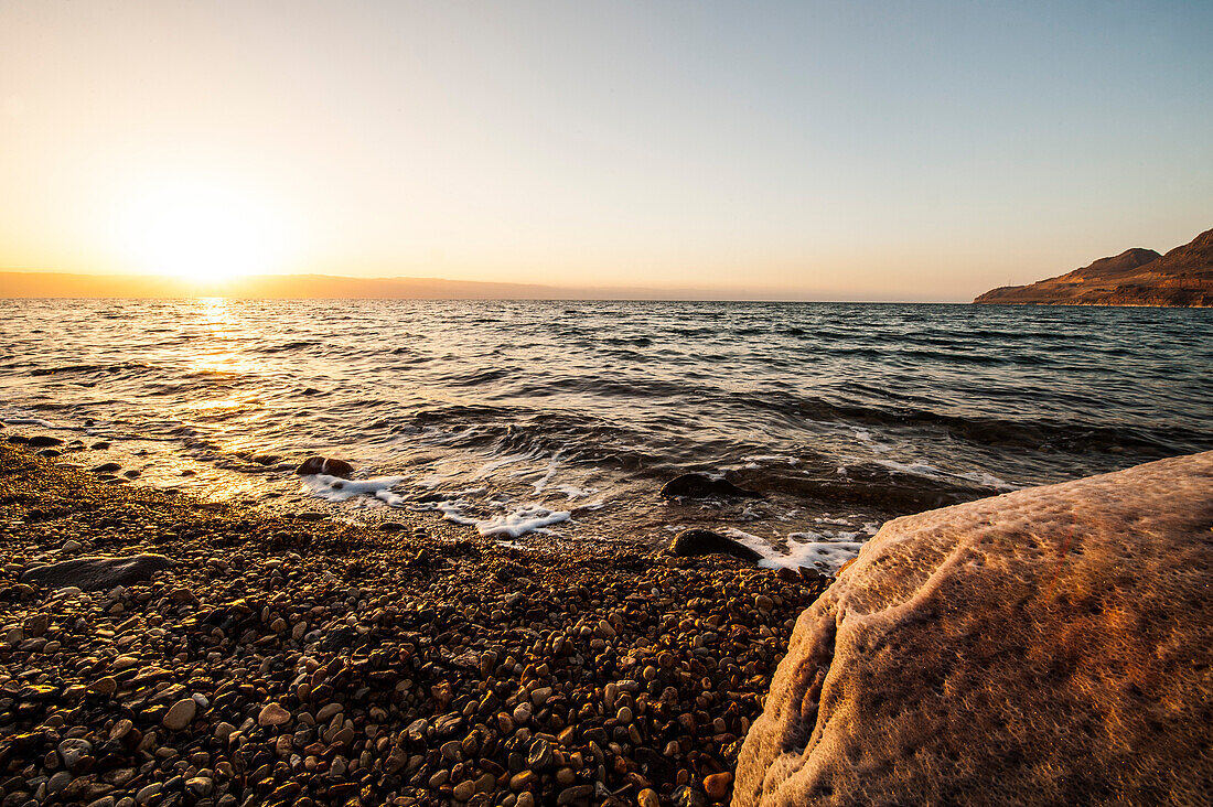 Salt encrusted stone in dead sea at sunset, Jordan, Middle East