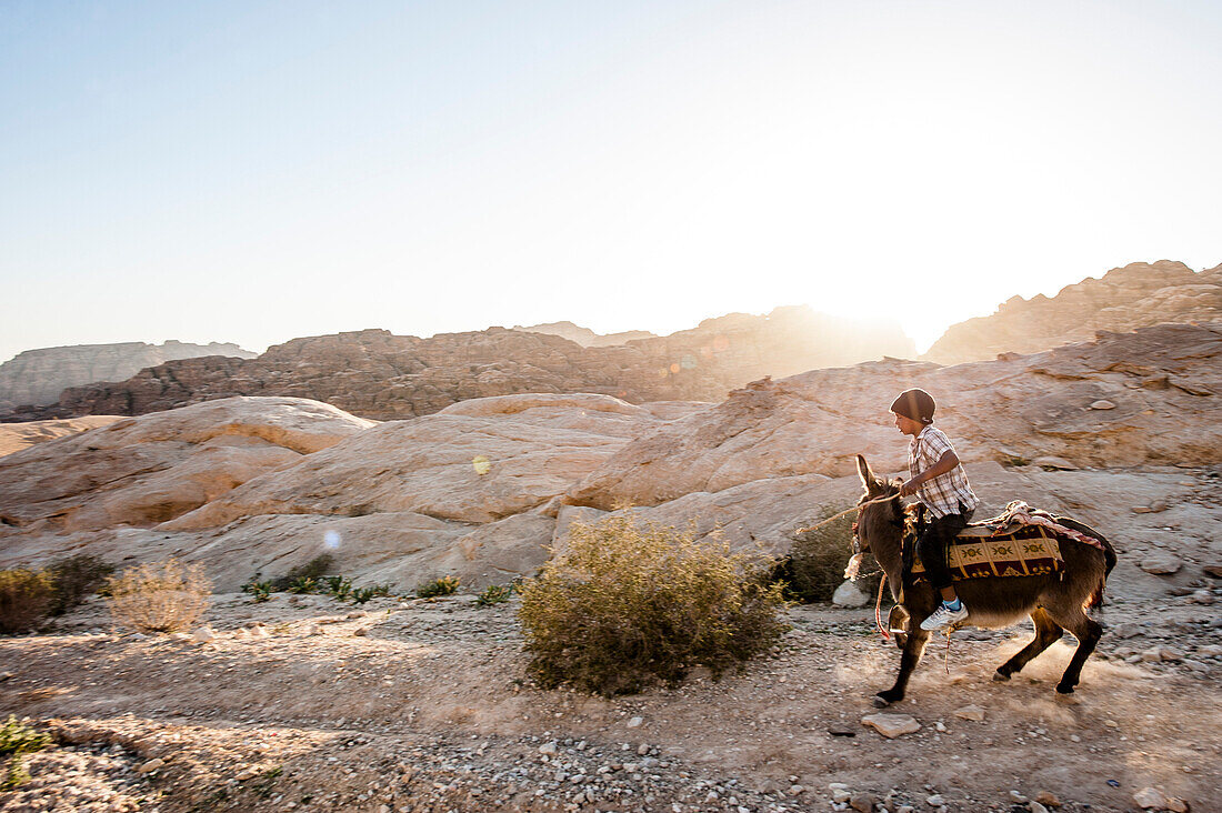 Junge reitet auf einem Esel, Wadi Musa, Jordanien, Naher Osten