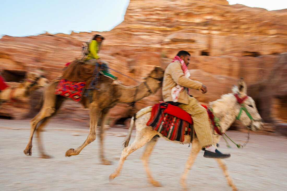 Männer reiten auf einem Kamel und einem Esel, Petra, Jordanien, Naher Osten