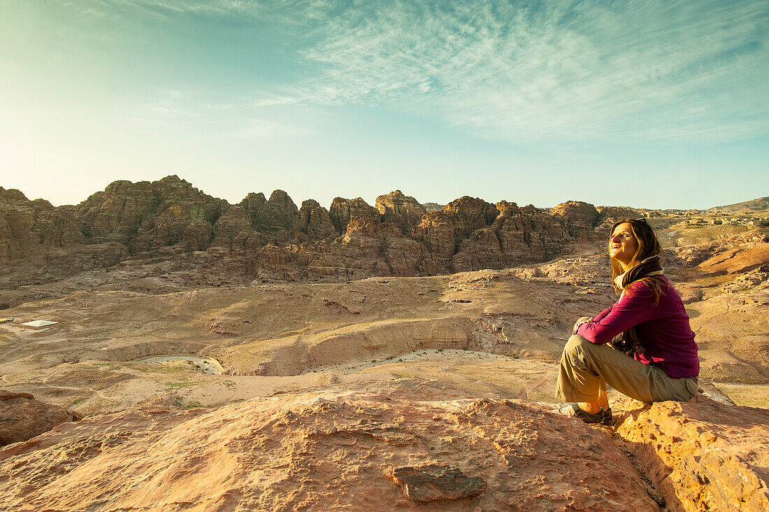 Frau sitzt auf einem Stein, Petra, Wadi Musa, Jordanien, Naher Osten