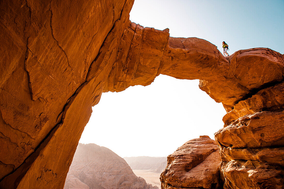Frau geht über Felsbrücken über den Jabal Burdah, Wadi Rum, Jordanien, Naher Osten