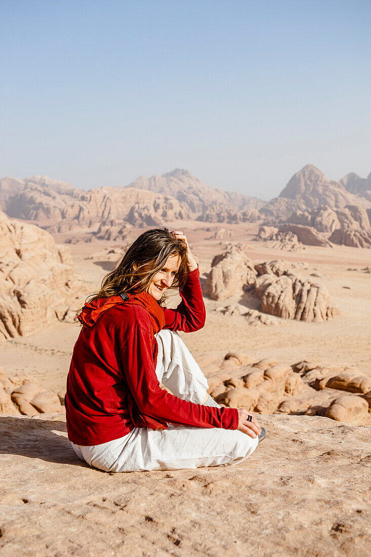 Frau rastet auf einem Felsen, Wadi Rum, Jordanien, Naher Osten
