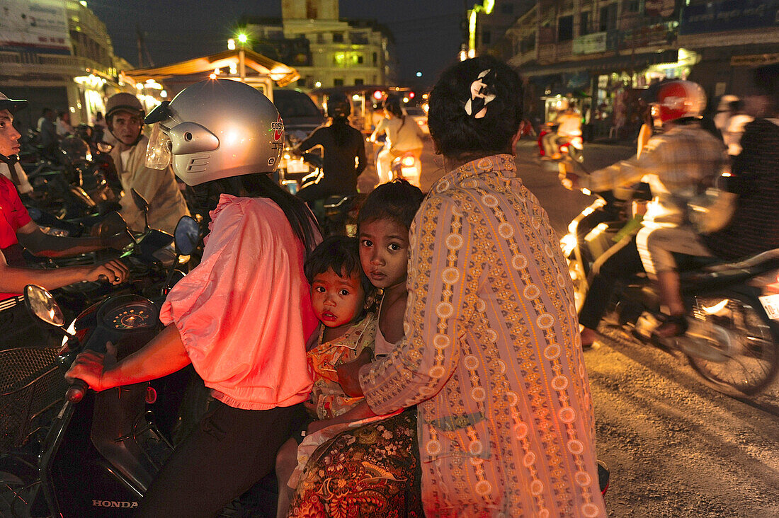 Zwei Frauen mit zwei Kindern auf einem Motorroller am Markt im Zentrum von Battambang, Kambodscha, Südost-Asien