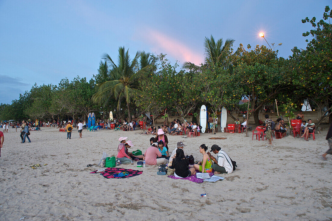 Chinesische Touristinnen lassen sich am Abend am Strand mit Henna bemalen, Kuta, Bali, Kleine Sundainseln, Indonesien